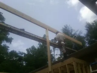 Carpenter setting a ridge beam over a new addition frame — Ice Dam Removal by Roofing Brothers in Williamson